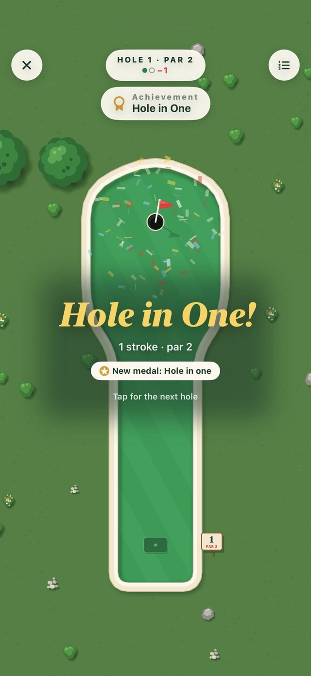 Greens hole 1 from above with confetti over the cup and a gold Hole in One! banner